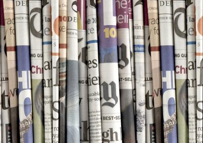 Diarios apilados, representando la sección de repercusiones en la prensa que hemos tenido a lo largo de los años.