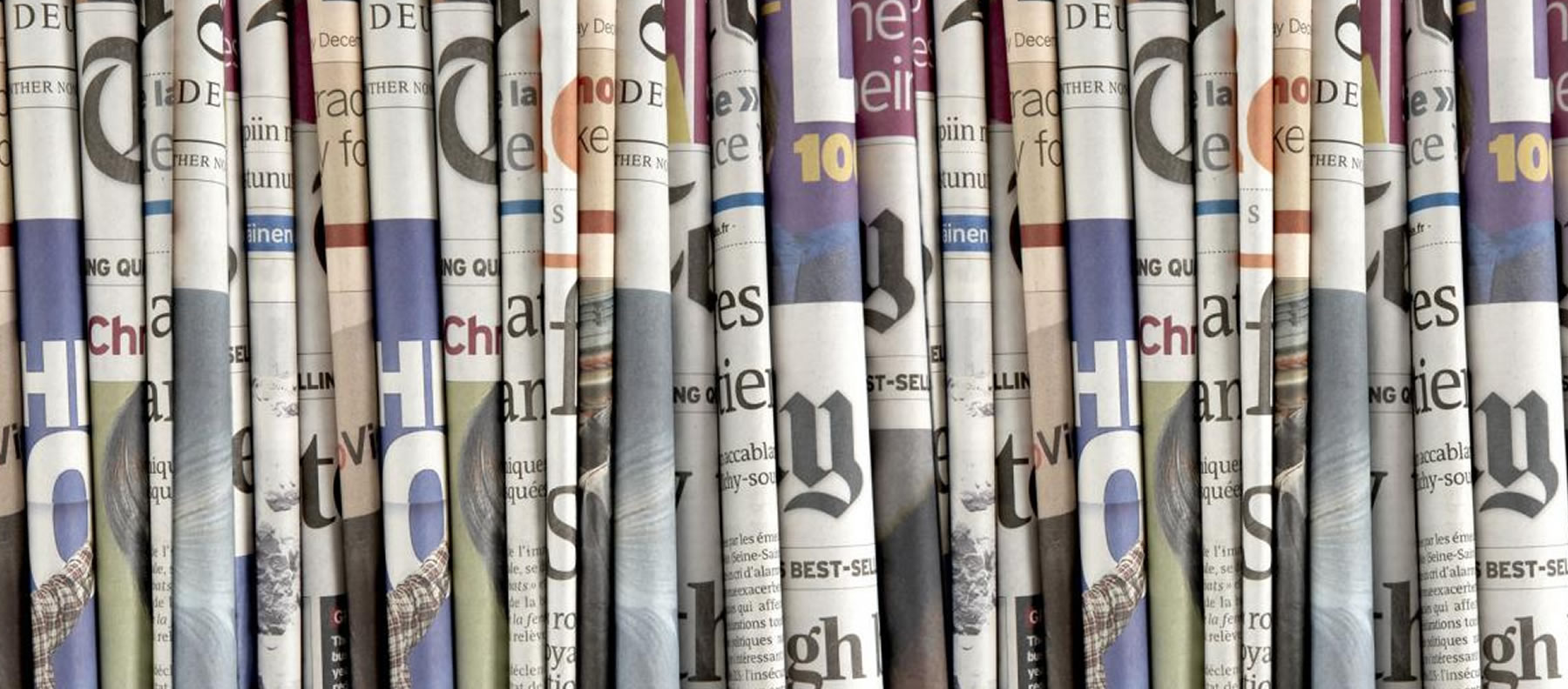 Diarios apilados, representando la sección de repercusiones en la prensa que hemos tenido a lo largo de los años.